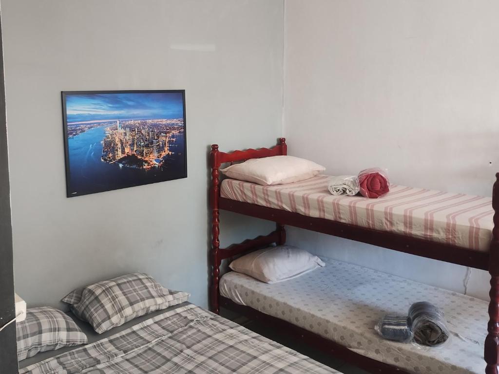 a room with two bunk beds and a picture on the wall at kitnet08 para 04 pessoas bem localizada garagem in Ourinhos