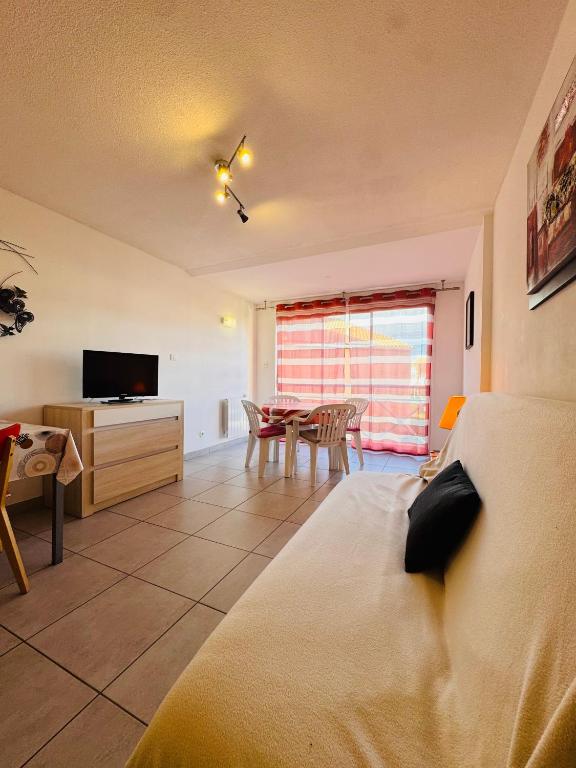 a living room with a bed and a dining room at Les Soleillades-T2 pour 5 pers-piscine, parking privé- LaConciergerieByNina in Palavas-les-Flots