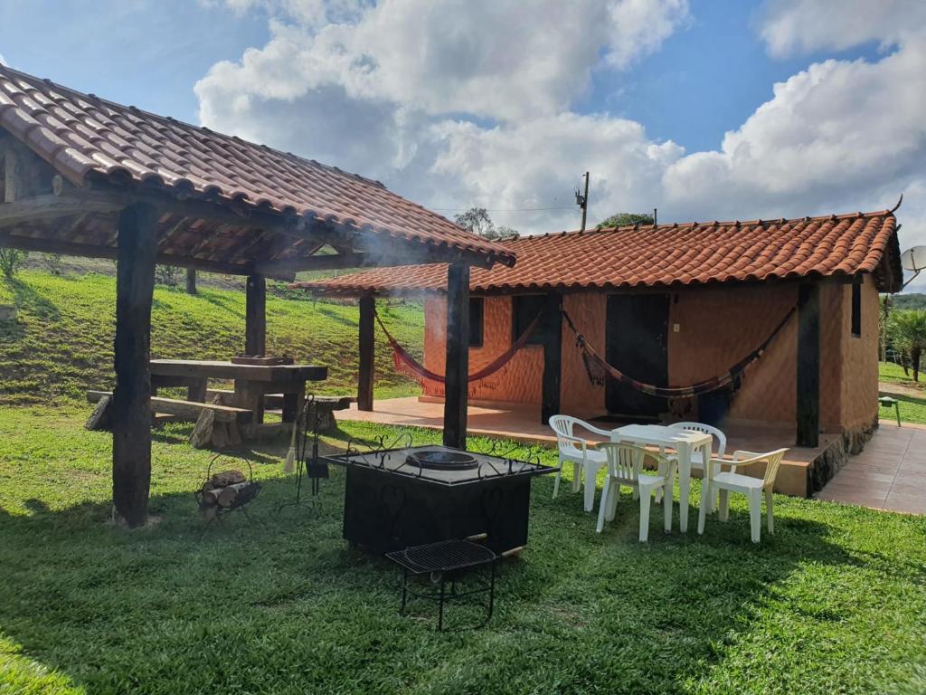 a pavilion with a table and chairs in a yard at Sossego Da Mata in Santo Antônio do Leite