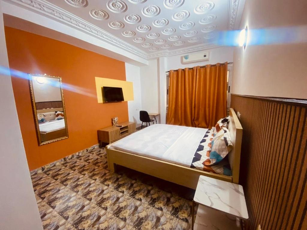 una camera da letto con un letto e uno specchio di Bethany Hotel a Abidjan