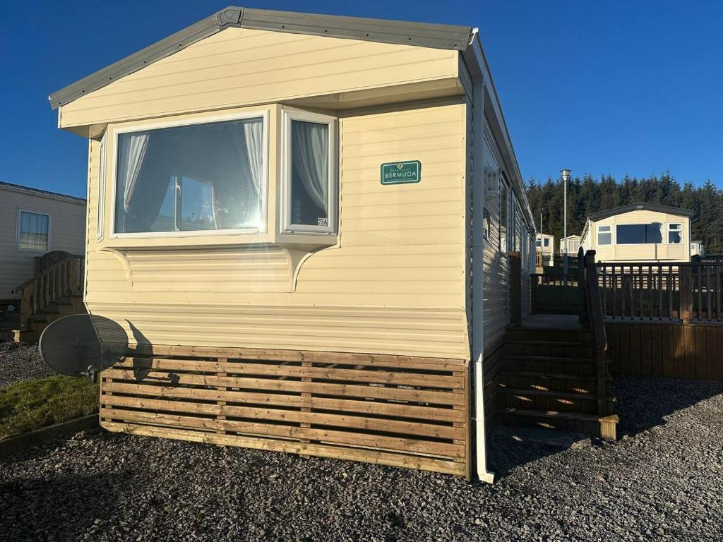 a small house with a window on the side of it at Cozy Donegal Caravan in Dunkineely