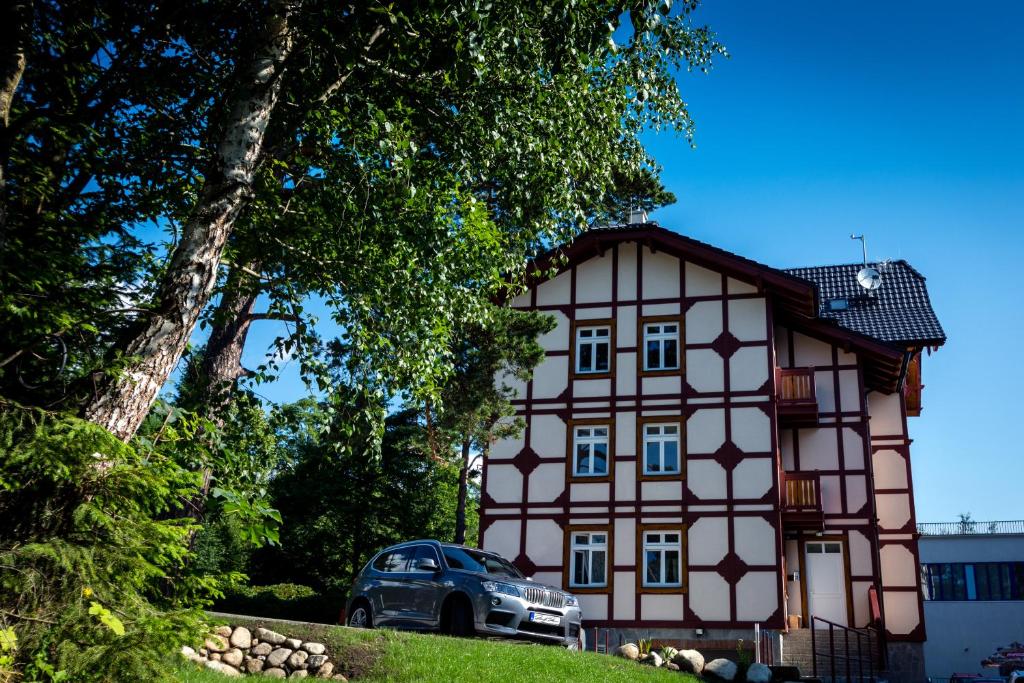 a house with a car parked in front of it at Apartments Marilyn in Tatranská Lomnica
