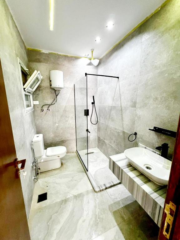 a bathroom with a shower and a toilet and a sink at رويال جاردن سويت in Cairo