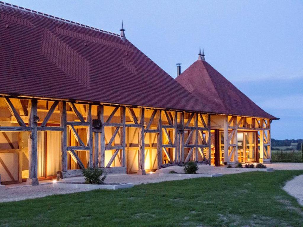 um grande edifício de madeira com um telhado vermelho em Hameau des Damayots em Montbeugny