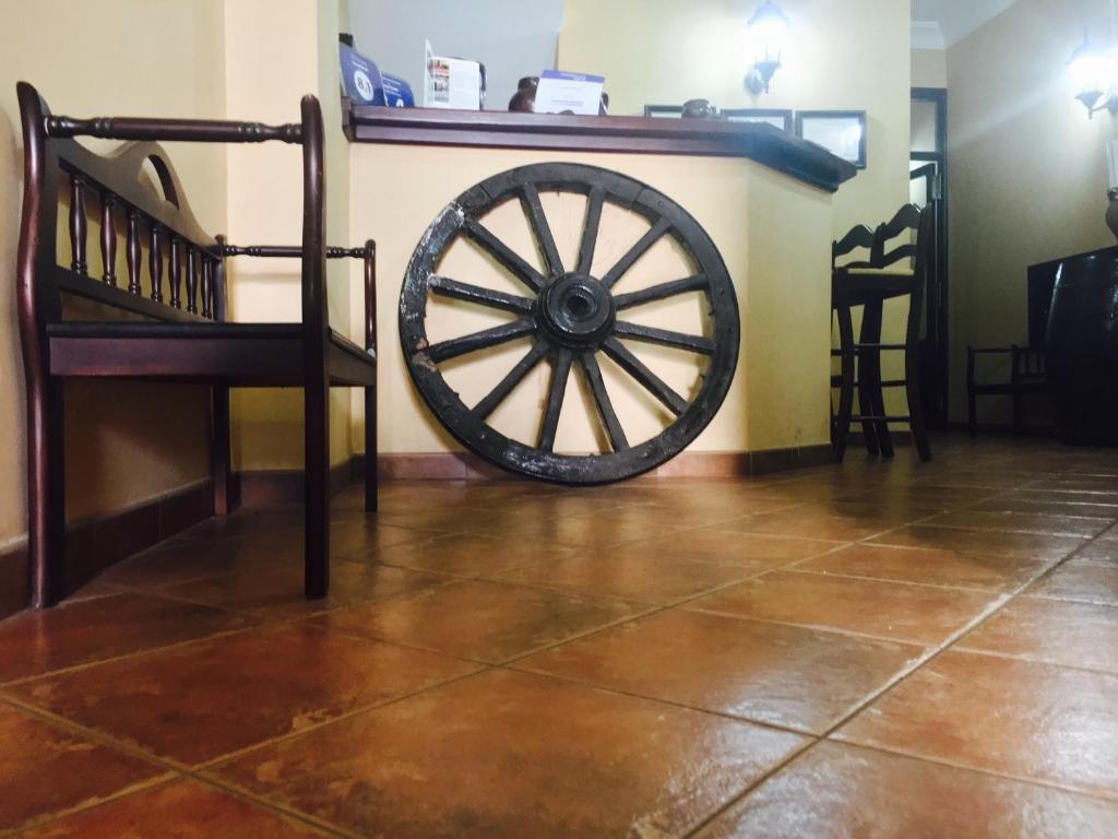 une roue de wagon en bois assise à côté d'un mur dans l'établissement Hostal Pechi, à Huévar