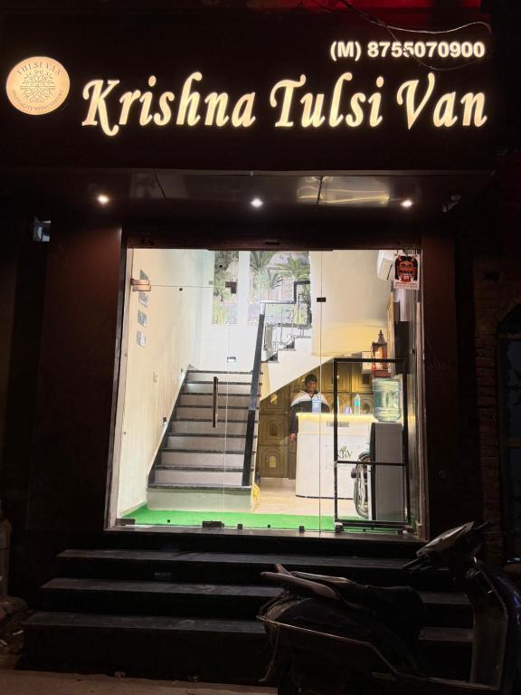 a sign for a restaurant with stairs in the window at Hotel Krishna Tulsi Van - Near Bankey Bihari & ISKCON in Vrindāvan