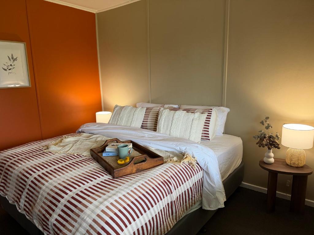 a bedroom with a bed with a tray of food on it at Kangaroo Cottage in Hay