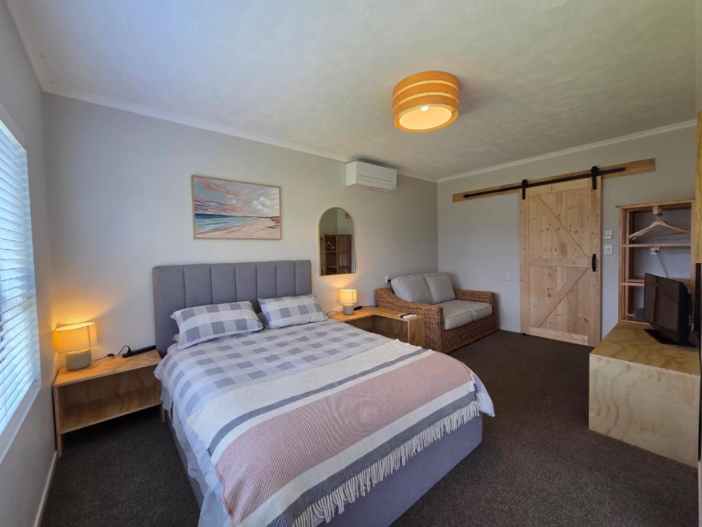 a bedroom with a large bed and a sliding door at Links View Retreat in Omokoroa