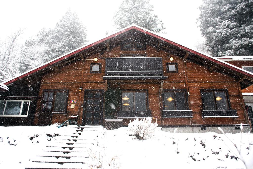 davor ein schneebedecktes Haus in der Unterkunft miscu in Minakami