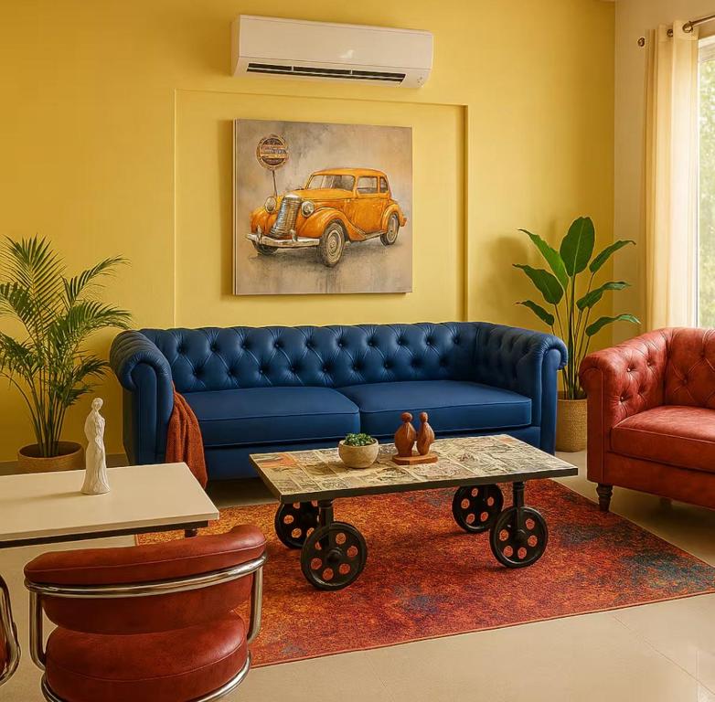 a living room with a blue couch and a table at Irida 2bhk private pool viila in Assagao