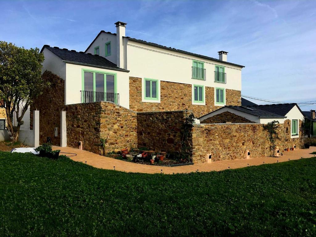 a large house with a stone wall at El Sueño, Parrita in Barres