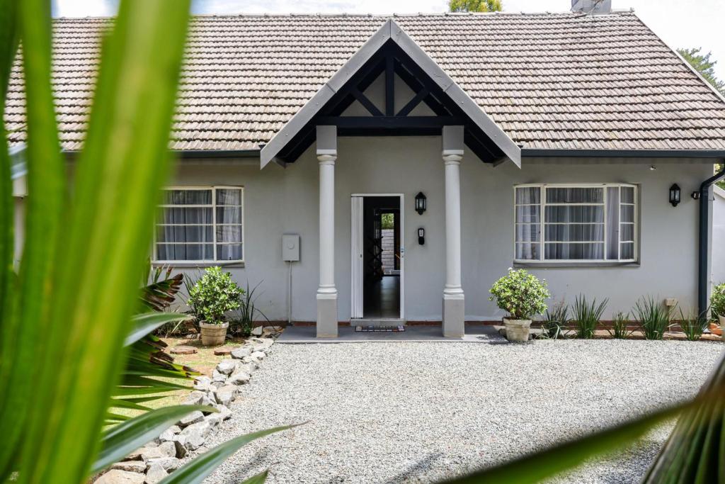 a white house with a black roof at Nest - The Homestead in Howick