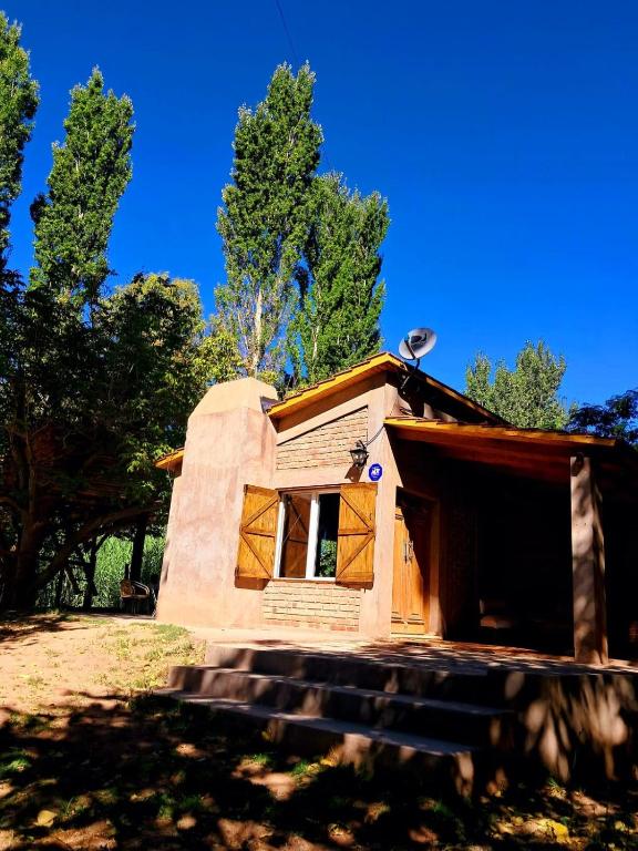 a tiny house in a field with trees in the background at Barreal La Templanza Casa de Campo in Barreal