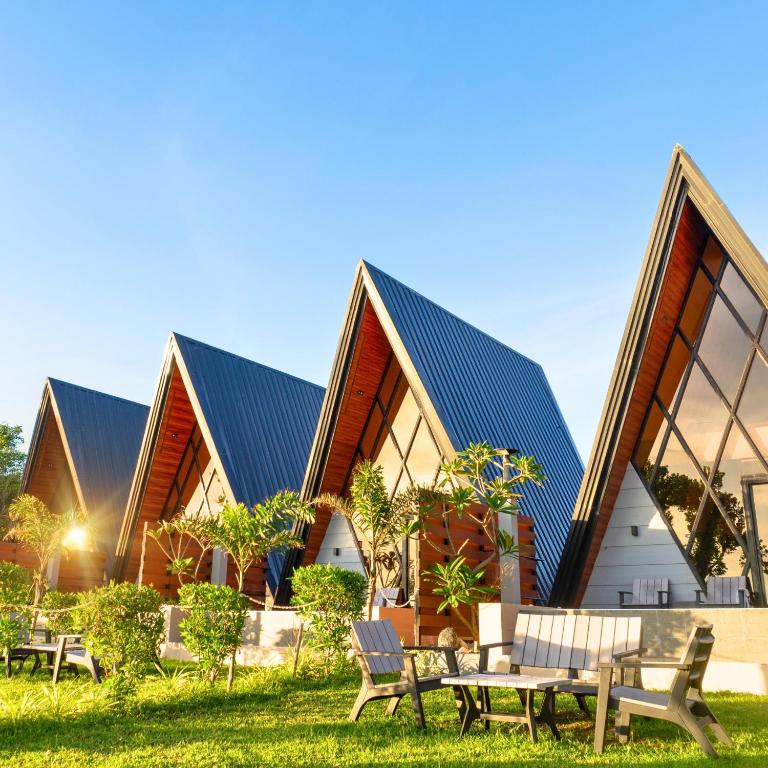 a building with benches and tables in the grass at Solsticio Azzul Beach Resort in Pandan