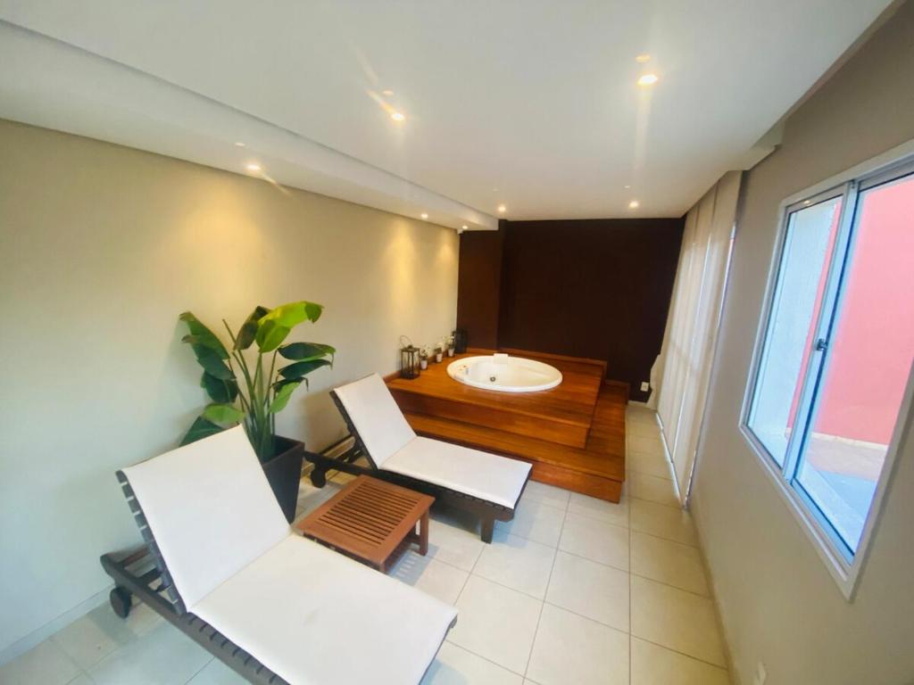 a bathroom with a sink and a chair and a tub at Play Ilhotas - Centro Teresina in Teresina