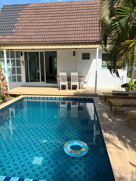 a swimming pool in front of a house at Penn house with shared pool in Ko Raeng
