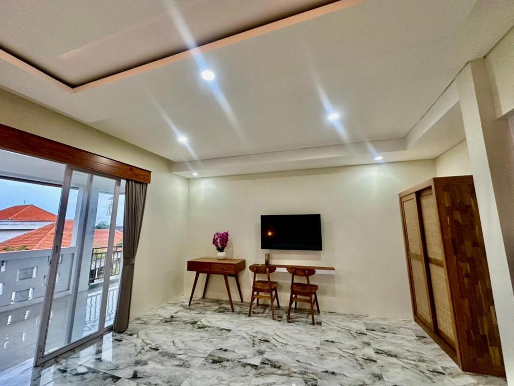 a living room with a table and a tv on the ceiling at Agustik Villas in Badung
