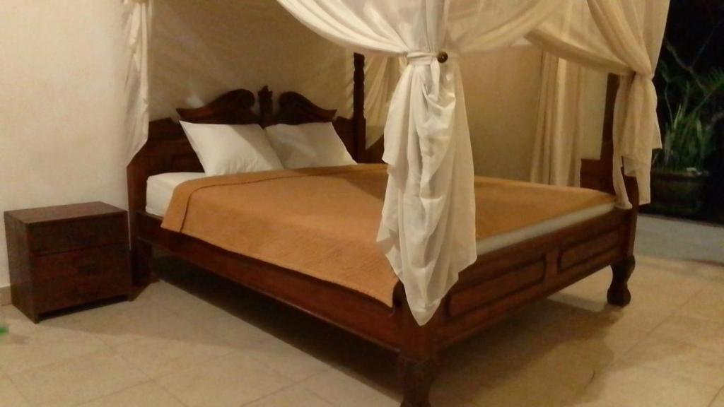 a bedroom with a bed with a canopy at Kubu shanti 1 in Ubud