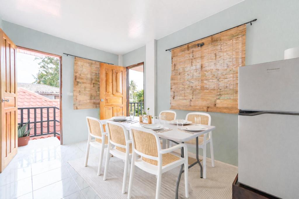 a kitchen and dining room with a white table and chairs at Bijunas Homestay in General Luna