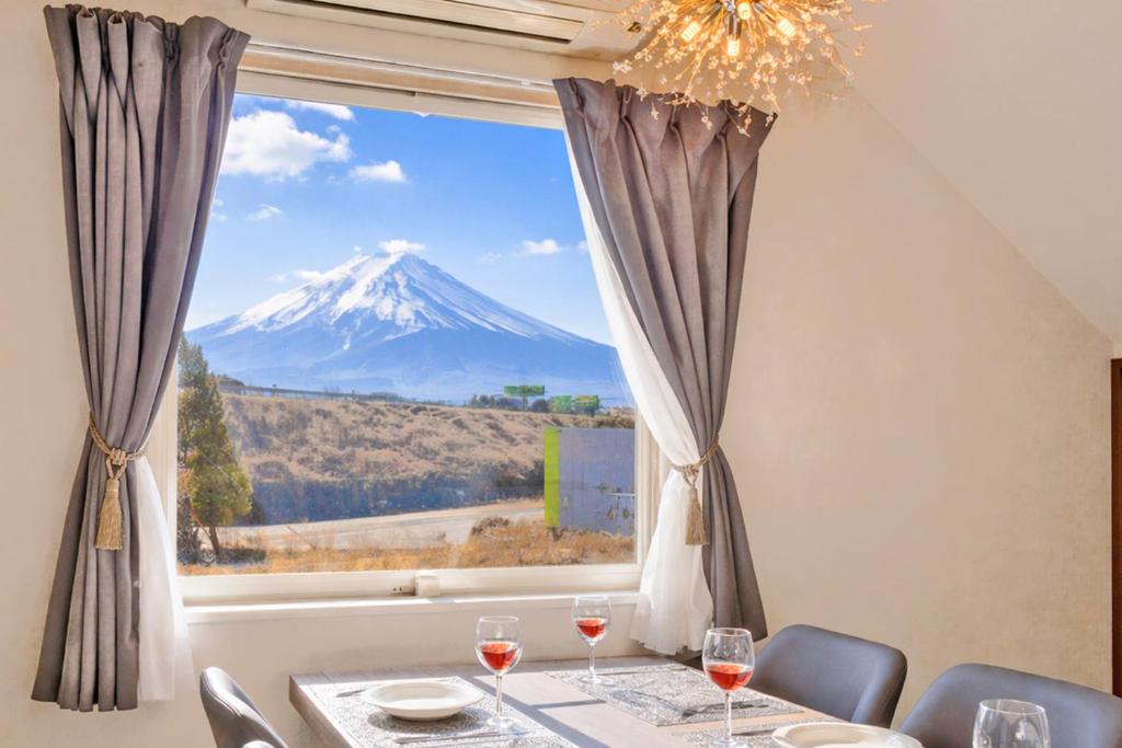 a table with a view of a mountain through a window at 不二咲 in Fujiyoshida