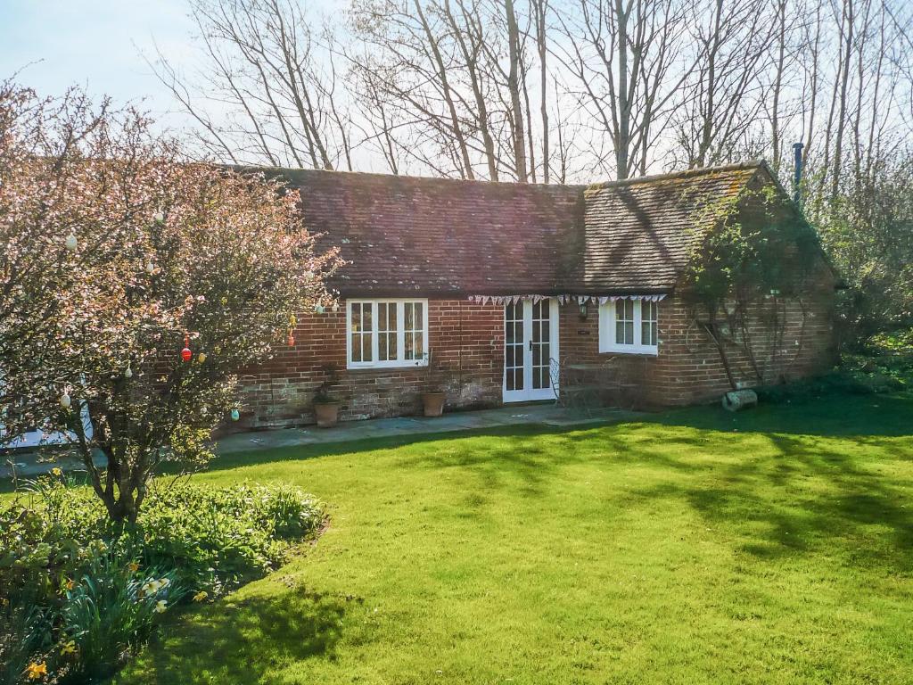 a brick house with a grass yard in front of it at Oaklands Farm - Cottage 4 in Broughton