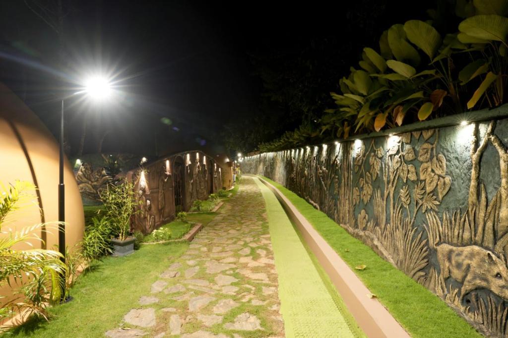 a walkway with graffiti on a wall at night at Lake Lagoon Moonhills in Mennānyam
