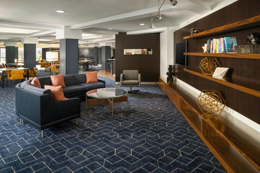 a lobby with a couch and a table and chairs at Courtyard Hartford Cromwell in Cromwell