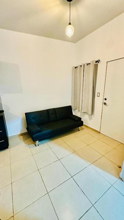 a living room with a black couch in a room at Casa de Sasha in El Matazano