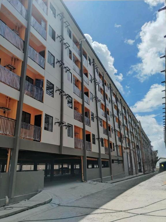 a large apartment building with balconies on a street at The Cozy Nook - Dorm in Batangas City