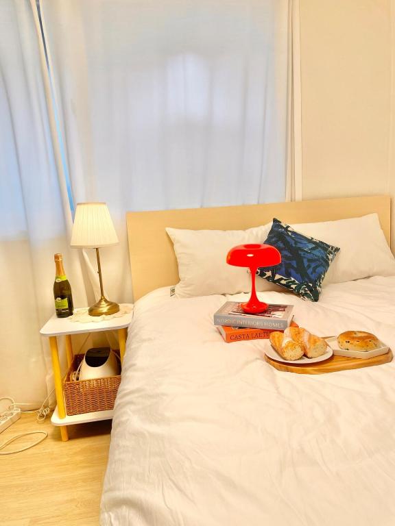 a tray of food on a bed with a plate of food at Finetree House in Samgong