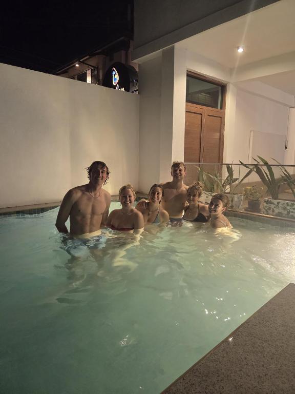 a group of people in a swimming pool at Ceylon Lodge - Airport Transit Hostel in Negombo