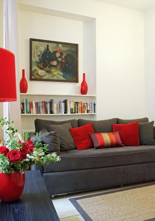 un salon avec un canapé gris avec des coussins rouges dans l'établissement Apartment Bac St. Germain, à Paris