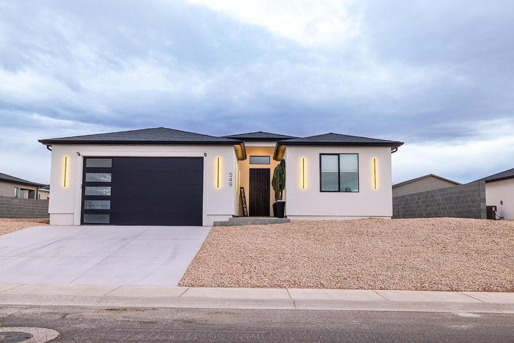 a white house with a black garage at The Mustang Collection 49 in Page