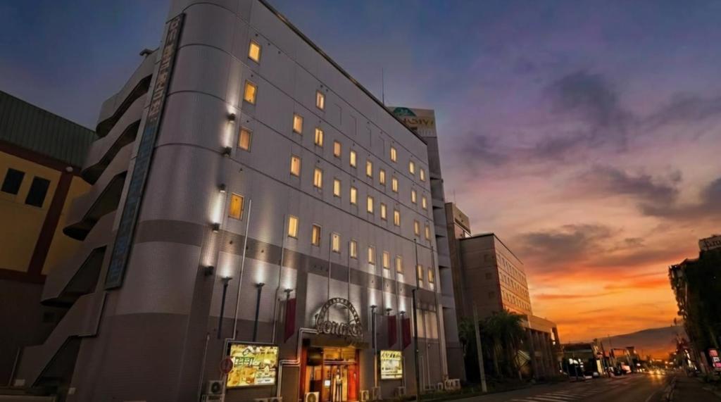 a building on a street with a sunset in the background at ホテルサンモール in Asahi