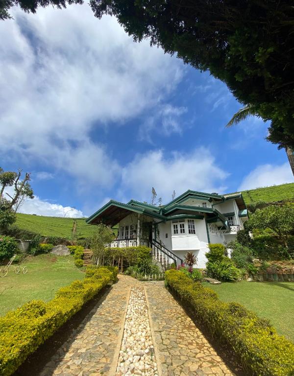 a house on a hill with a cobblestone driveway at Whispering Hills in Nuwara Eliya