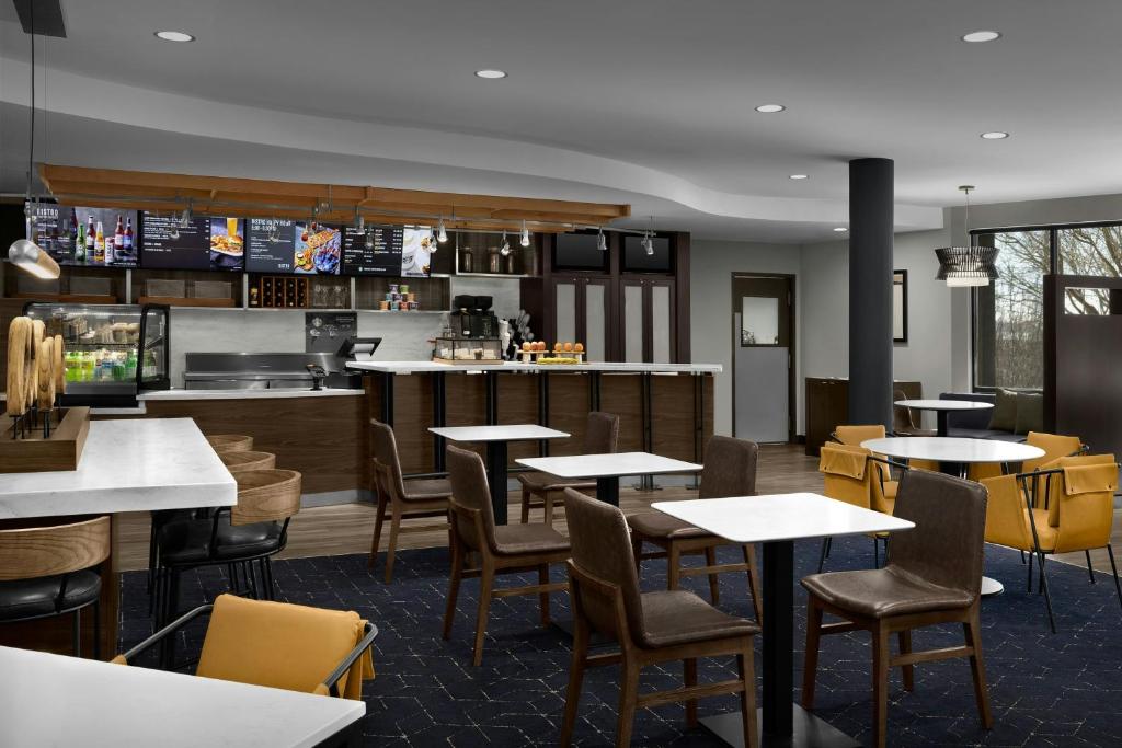 a restaurant with tables and chairs and a kitchen at Courtyard Danville in Danville