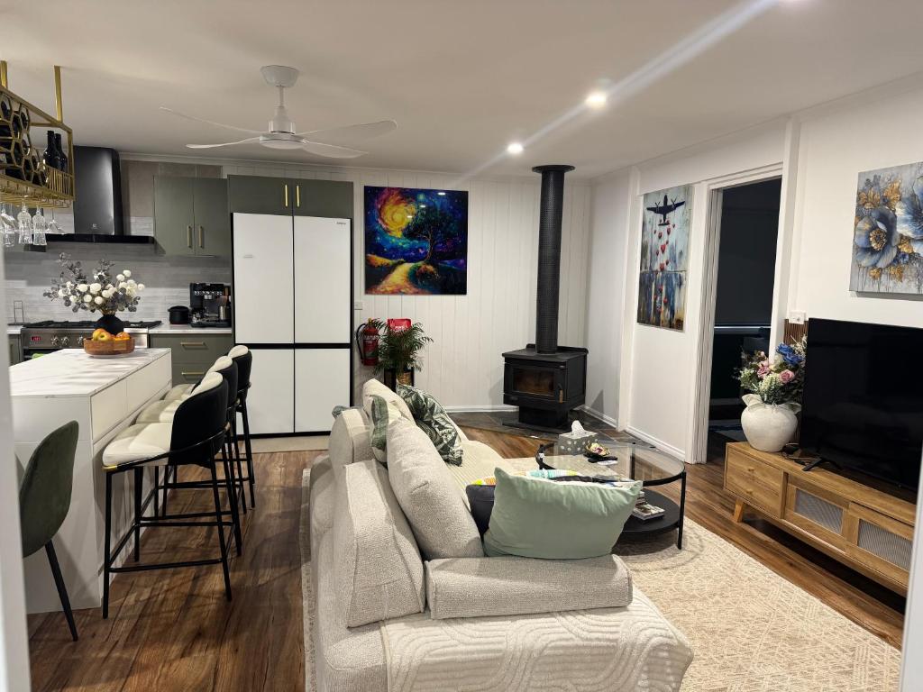 a living room with a couch and a kitchen at Brigidas Guest House in Bairnsdale