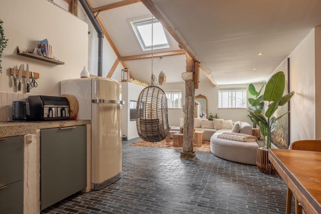 a kitchen with a refrigerator and a living room at Somers Loft in Zuid-Beijerland