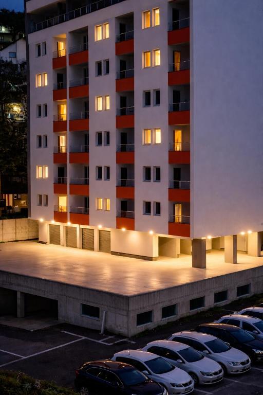 a parking lot with parked cars in front of a building at Muki Oaza Apartman in Tuzla