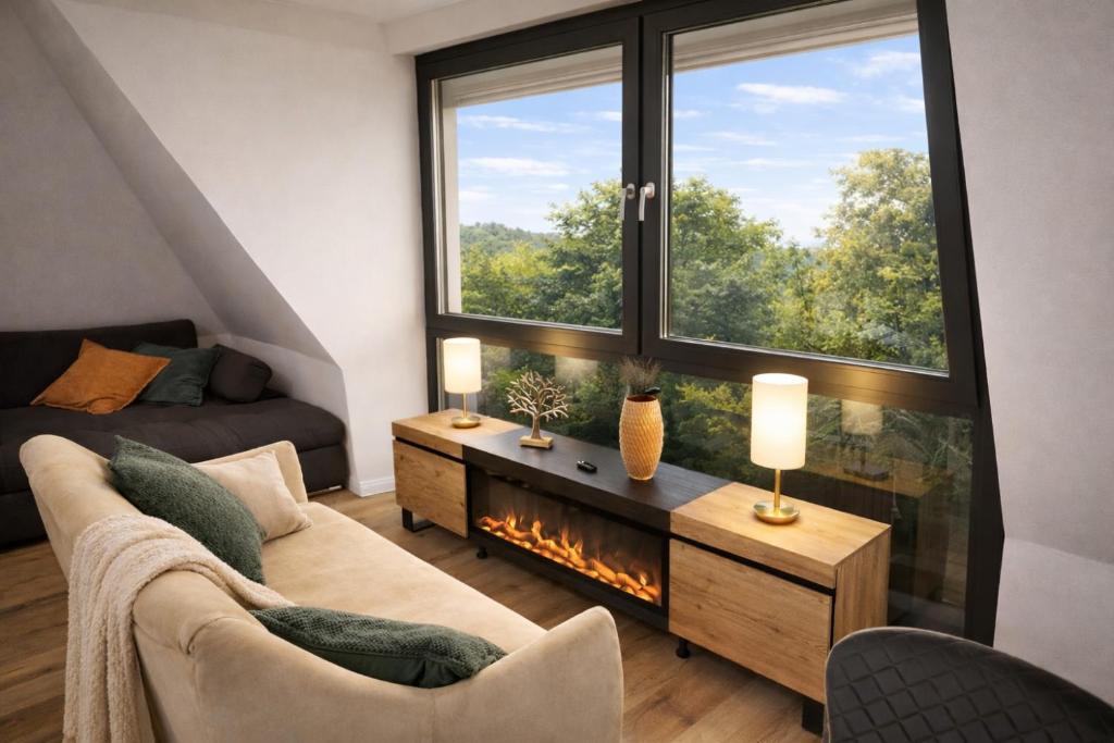 a living room with a couch and a fireplace at Ferienwohnung Niki am Straussee Seeblick und Kamin für bis zu 12 Personen in Strausberg