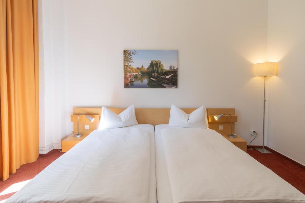 Dos camas en una habitación de hotel con sábanas blancas en Hotel 26, en Berlín