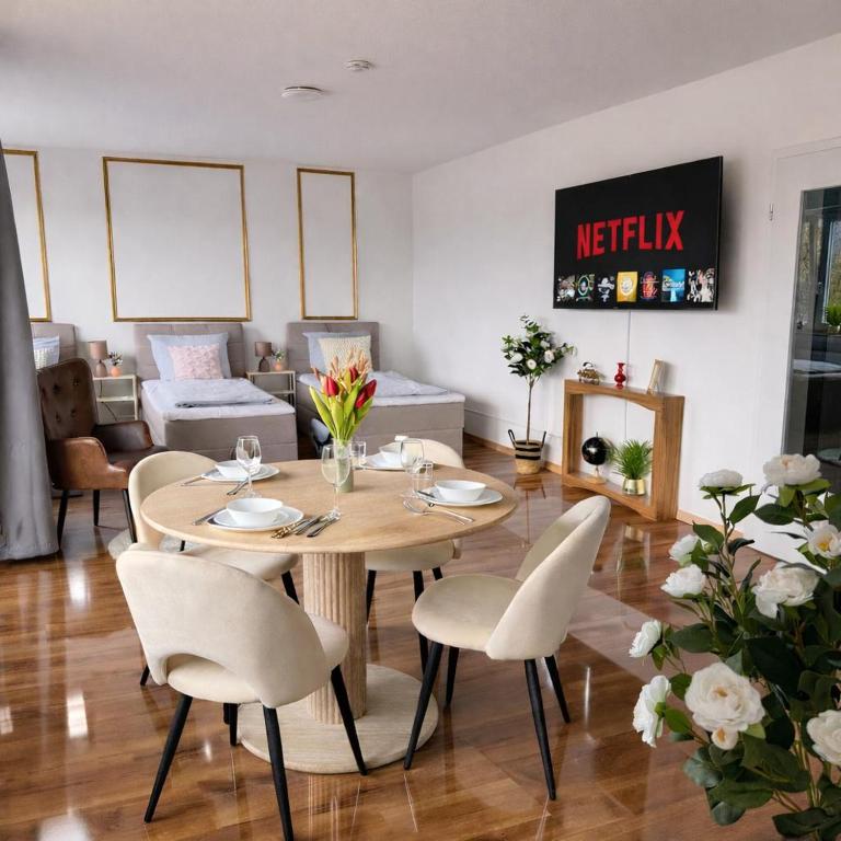 a dining table and chairs in a living room at Penthouse mit Deisterblick & Balkon in Barsinghausen