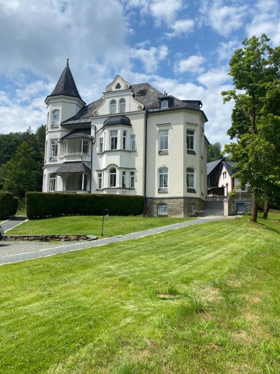 a large white house with a large yard at Ferienwohnung Marie in Bad Elster