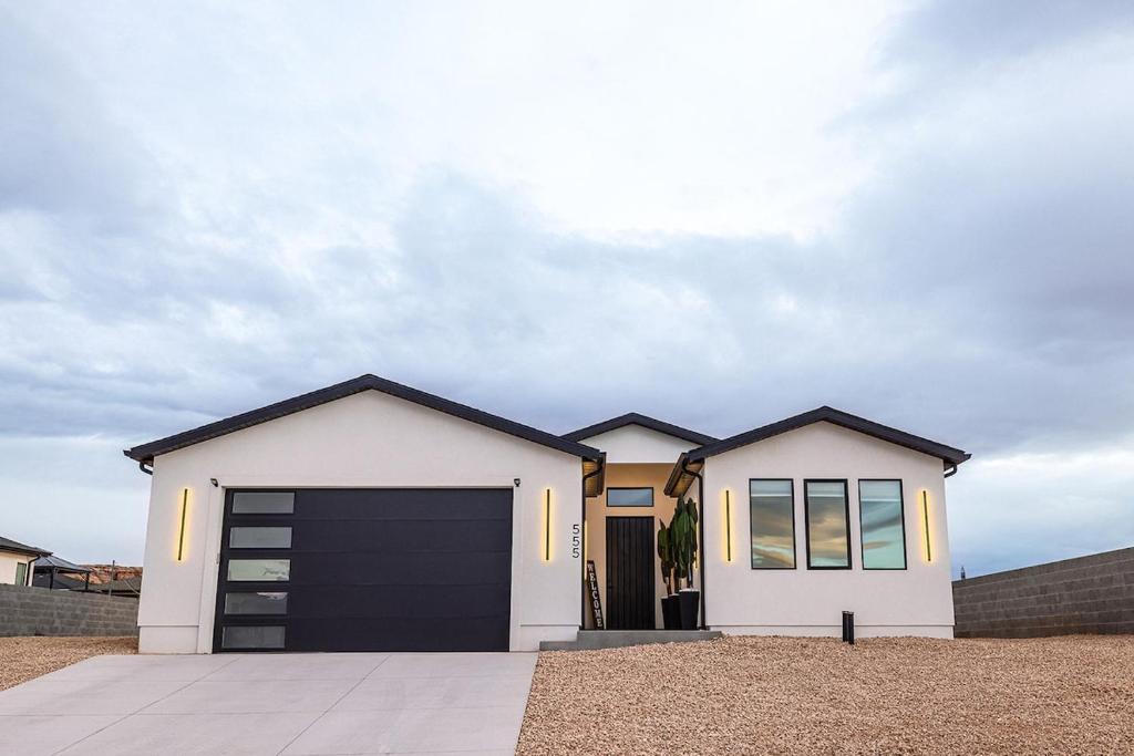 a white house with a black garage at The Mustang Collection 55 in Page