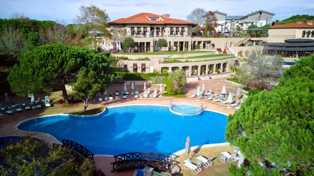 an overhead view of a swimming pool in front of a mansion at Kemer Country Hotel İstanbul in Istanbul