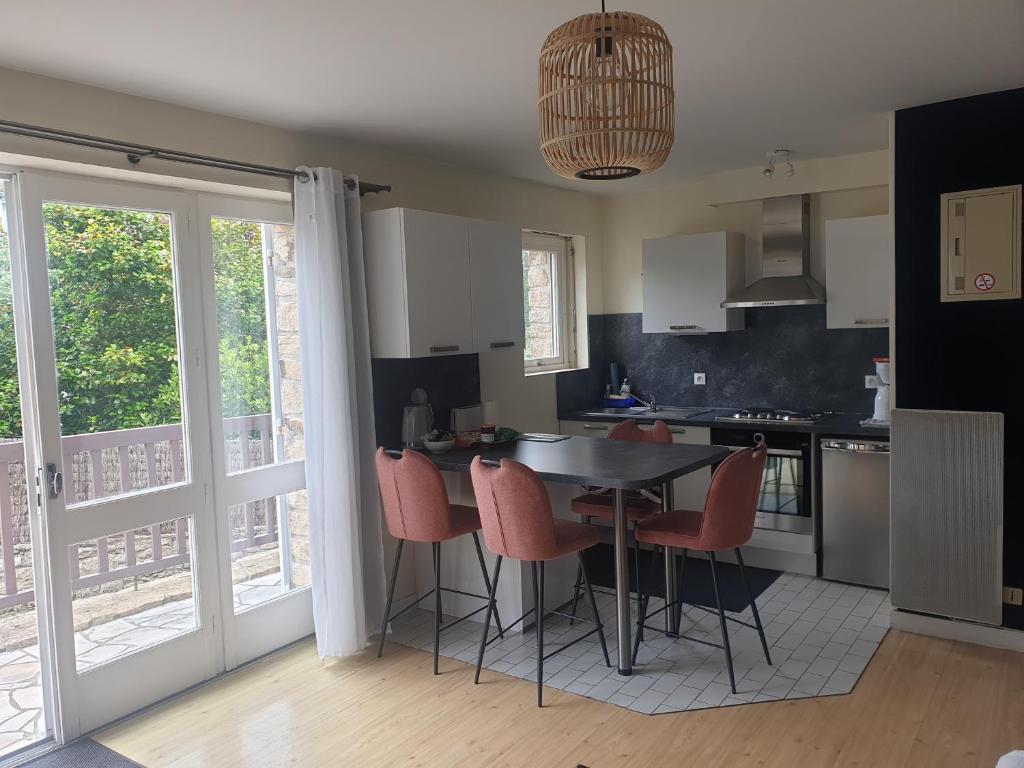 a kitchen with a table and chairs and a kitchen with a door at Studio La Trinité sur Mer in La Trinité-sur-Mer