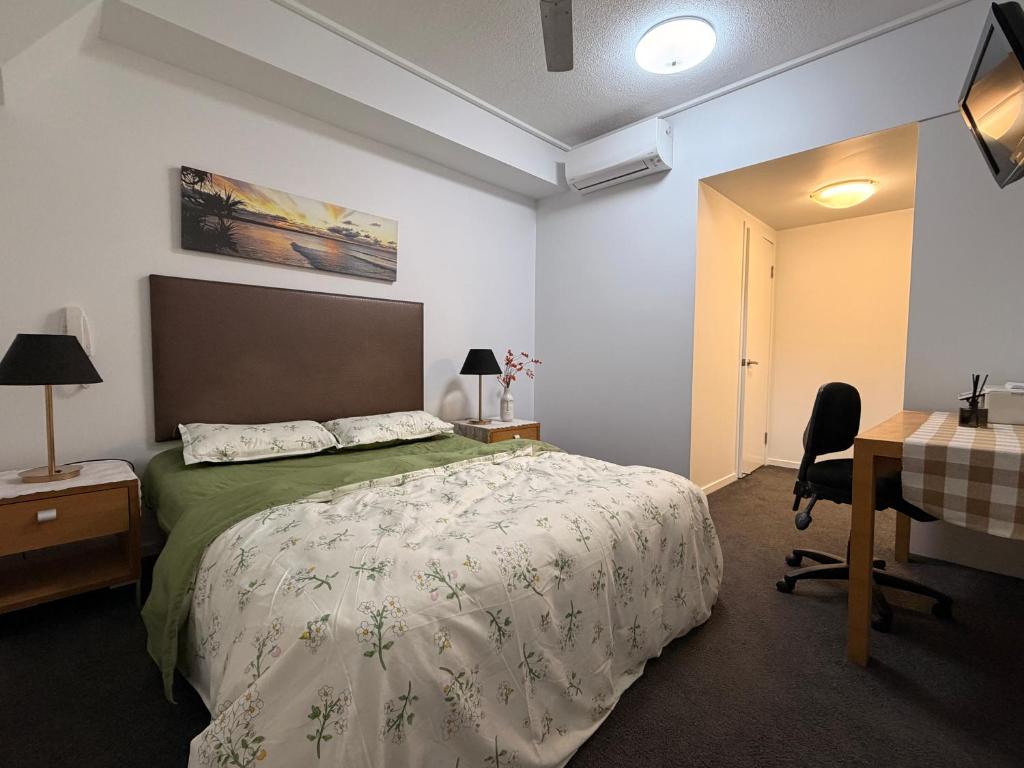 a bedroom with a bed and a desk and a computer at TJ Homes in Ross Island