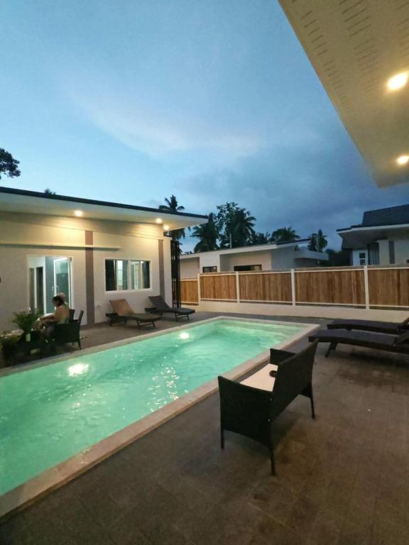 a swimming pool in front of a house at jessi house pool in Ban Nok
