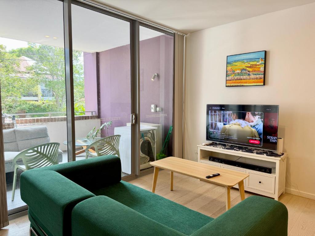 a living room with a couch and a tv at New Town Studio in Sydney