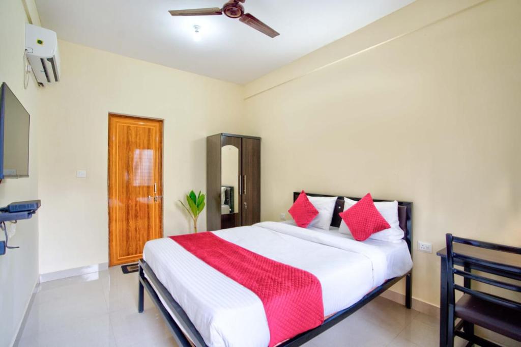a bedroom with a large bed with red pillows at Casa Nathan in Calangute